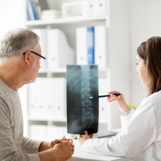Physician reviewing a spinal X-ray with an older patient