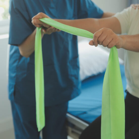 Therapist guiding a patient through resistance band rehabilitation