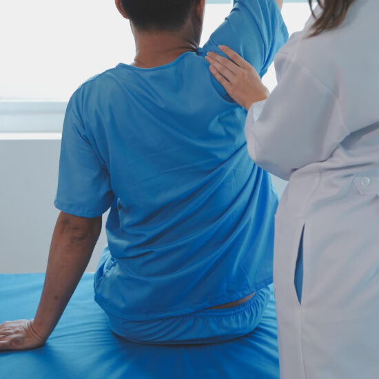 Therapist assessing a patient's back posture and movement
